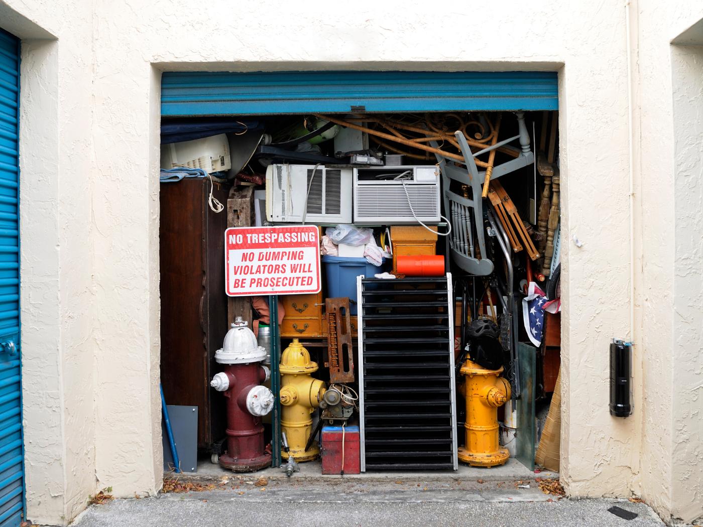 Storage unit packed floor to ceiling with furniture, appliances and boxes
