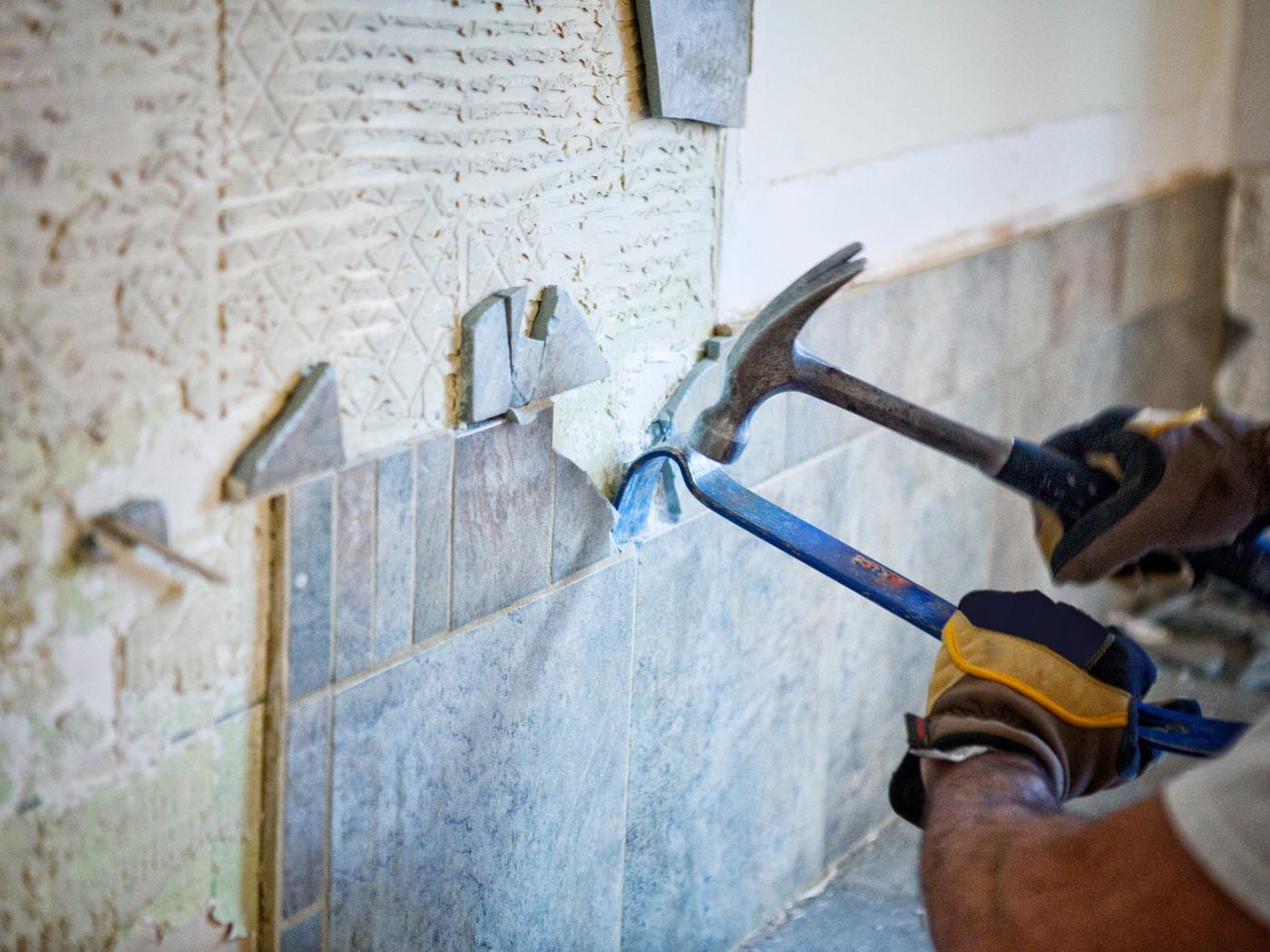 Tile being pried off a wall during an interior tear-out